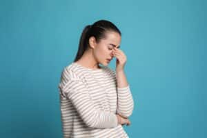 A woman pinching her nose because she has a migraine